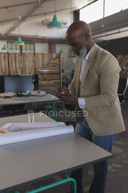 Мужчина руководитель с помощью цифрового планшета за столом в офисе — стоковое фото