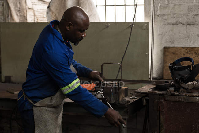 Side view of blacksmith working in workshop — Stock Photo