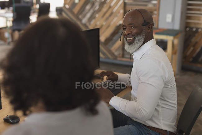 Happy executives interacting with each other in office — Stock Photo