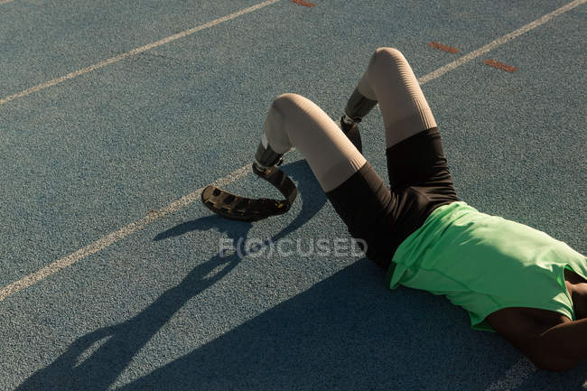 Athlète handicapé fatigué relaxant sur une piste de course — Photo de stock