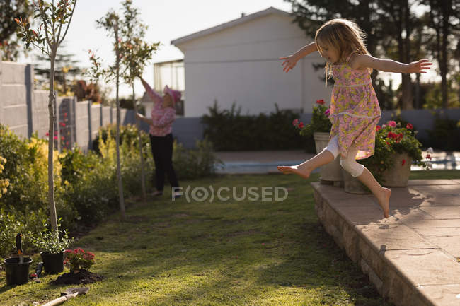 Дівчина грає в саду в сонячний день — стокове фото