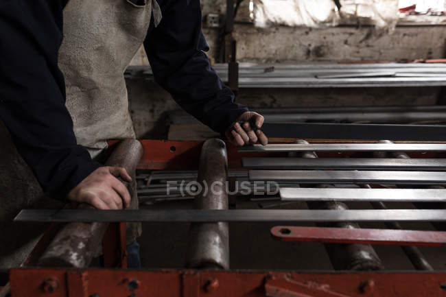 Mid section of blacksmith working in workshop — Stock Photo