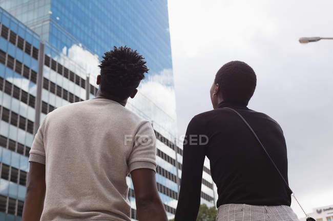 Вид сзади на пару, стоящую на городской улице — стоковое фото