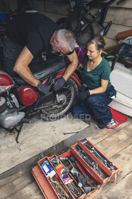 Висока кут зору механік ремонту мотоцикл в гаражі — стокове фото