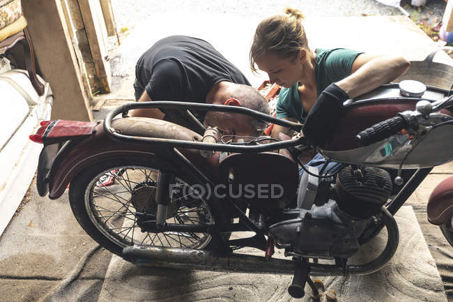 Vista ad alto angolo del meccanico che ripara la moto in garage — Foto stock