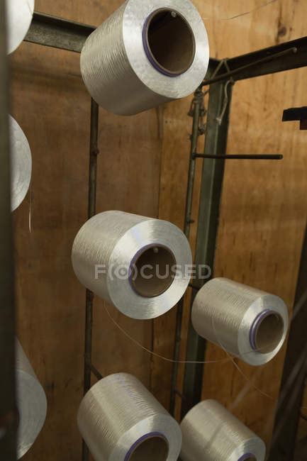 Primer plano de los rollos de rosca dispuestos en rack en la industria de fabricación de cuerdas - foto de stock