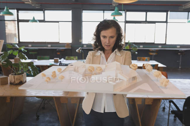 Femme cadre travaillant sur modèle de maison dans le bureau — Photo de stock