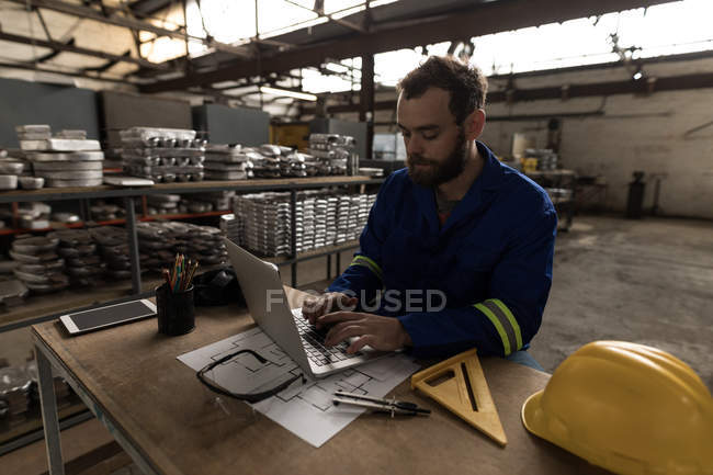 Чоловічий коваля, використовуючи ноутбук у майстерні — стокове фото