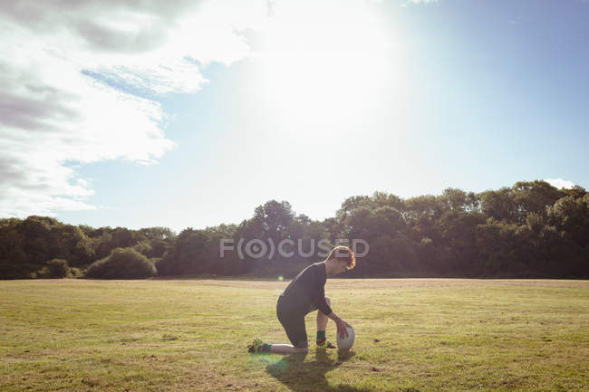 Giocatore di rugby che mette la palla da rugby in campo in una giornata di sole — Foto stock