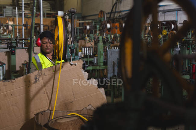 Trabajador atento que trabaja en la industria de fabricación de cuerdas - foto de stock