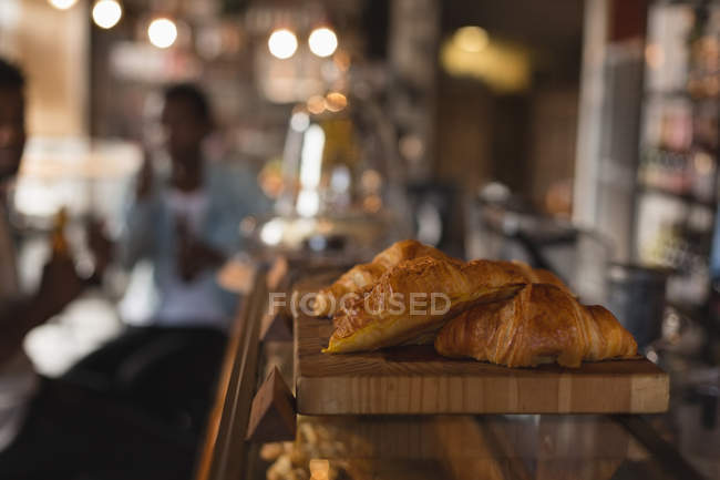 El primer plano del croissant en el mostrador en la cafetería - foto de stock