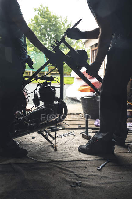 Bassa sezione di meccanico riparazione moto in garage — Foto stock
