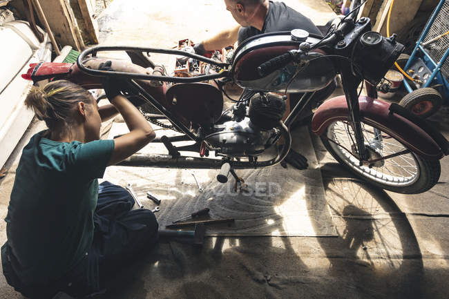 Vista ad alto angolo del meccanico che ripara la moto in garage — Foto stock