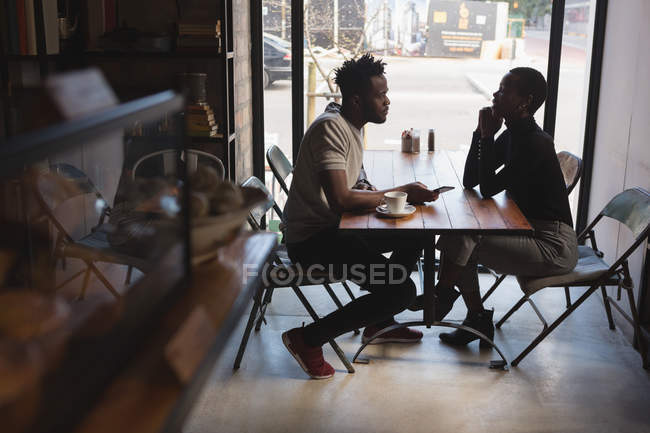 Вид збоку пари, що дивиться один на одного в кафе — стокове фото