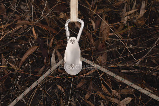 Close-up of rope passing through the hook in forest — Stock Photo