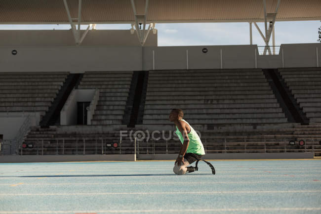 Вид сбоку спортсмена-инвалида отдыхающего на беговой дорожке — стоковое фото