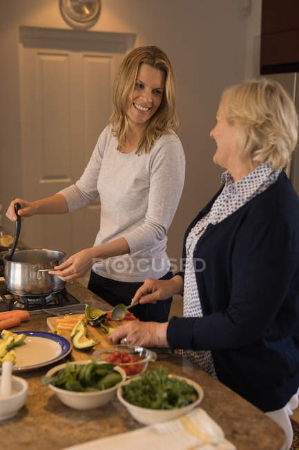 Mère et fille préparant la nourriture dans la cuisine à la maison — Photo de stock