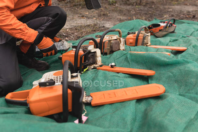 Close-up of chainsaw arranged and worker — Stock Photo