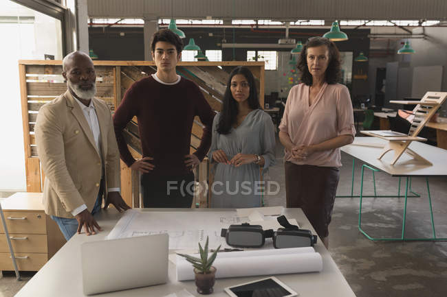 Portrait of confident executive standing at table in office — Stock Photo