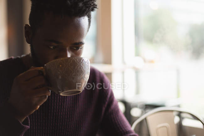 Крупный план человека, пьющего кофе в кафе — стоковое фото