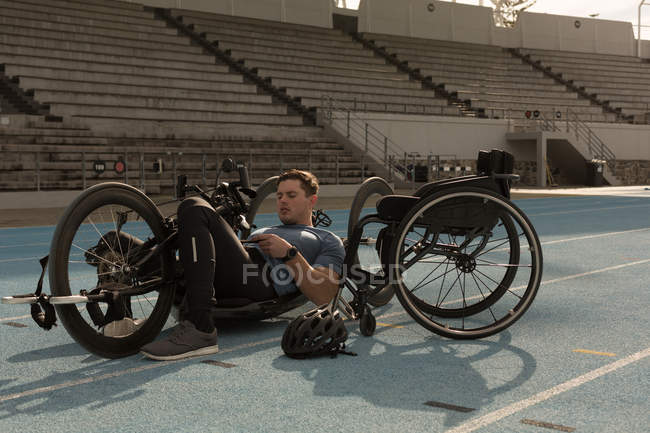 Atleta discapacitado masculino con silla de ruedas en una pista de carreras - foto de stock