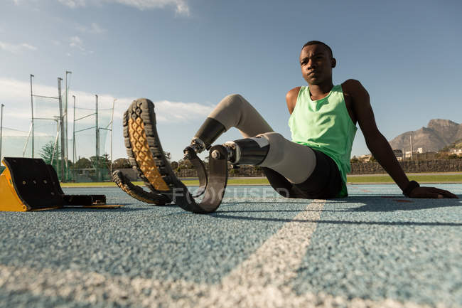 Уставший спортсмен-инвалид отдыхает на беговой дорожке — стоковое фото