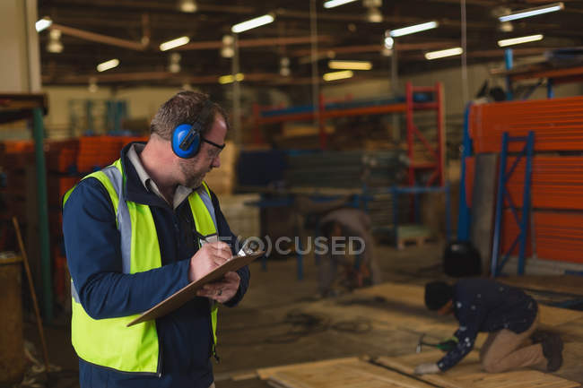 Worker writing on a clipboard in rope making industry — Stock Photo