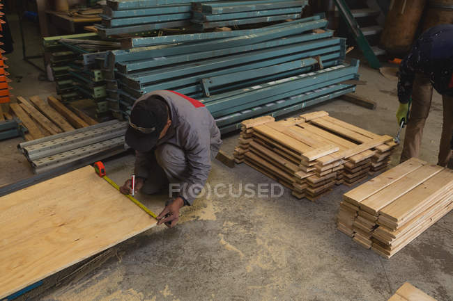 Travailleur mesurant la planche de bois dans l'industrie de fabrication de cordes — Photo de stock