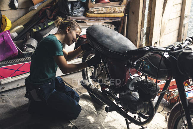 Mechanikerin repariert Motorrad in Garage — Stockfoto