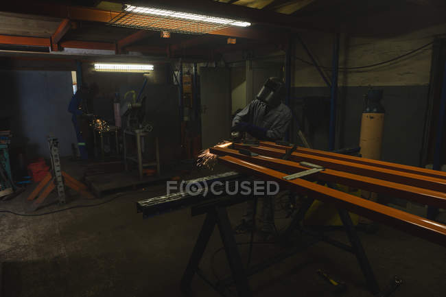 Внимательный работник, использующий шлифовальный станок в производстве канатов — стоковое фото