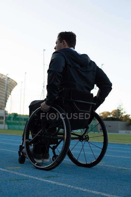 Rückansicht behinderter Sportler, der sich mit Rollstuhl bewegt — Stockfoto
