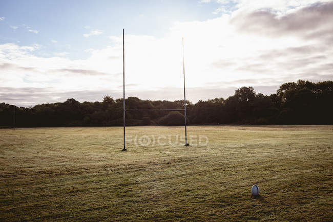 Pallone da rugby vuoto e palo porta in campo — Foto stock