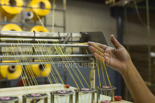 Gros plan du filetage de contrôle des travailleurs dans la machine à l'industrie de fabrication de cordes — Photo de stock