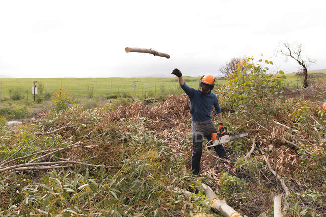 Taglialegna gettando tronco di legno nella foresta — Foto stock
