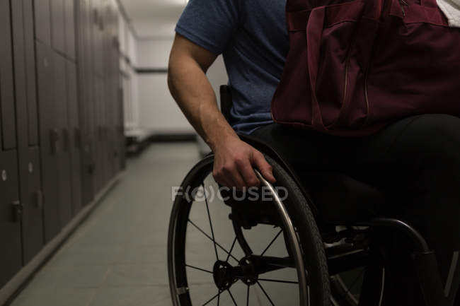 Partie médiane de l'homme handicapé avec son sac dans les vestiaires — Photo de stock