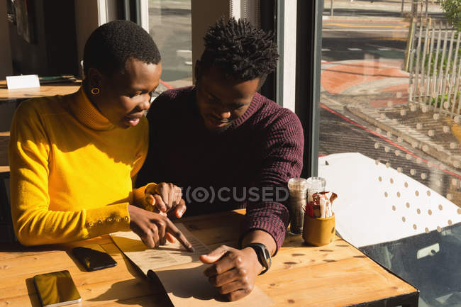 Couple looking at menu in cafe — Stock Photo