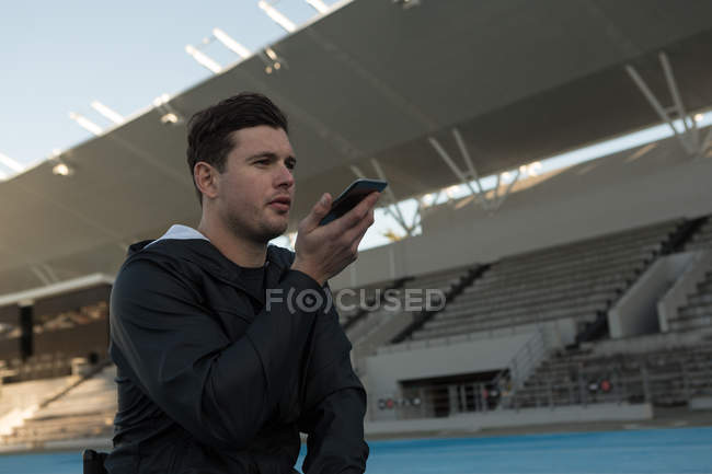 Atleta falando no celular em local de esportes — Fotografia de Stock