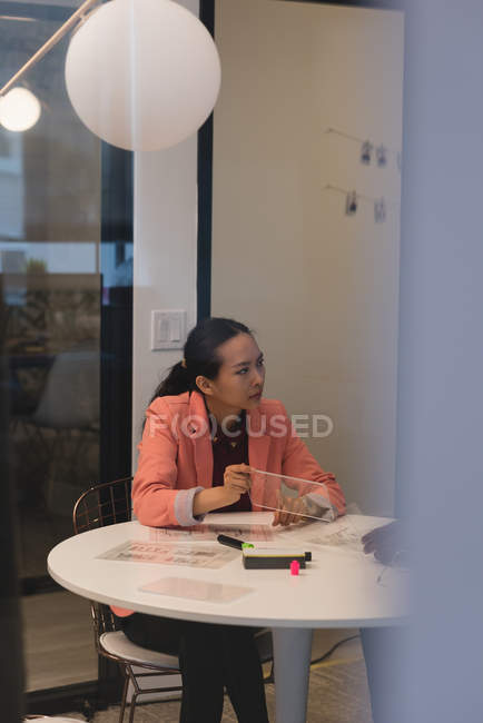 Деловая женщина показывает невидимый цифровой планшет своему коллеге в офисе — стоковое фото