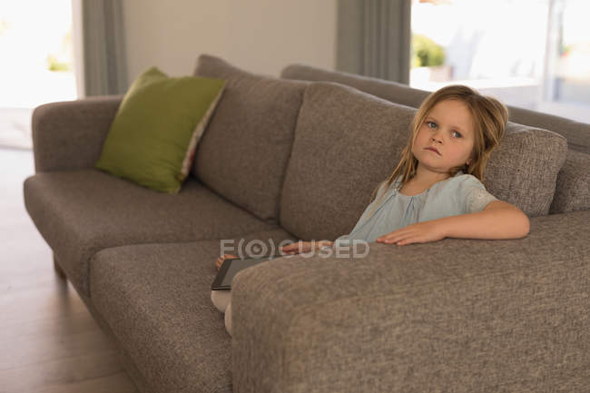 Девушка отдыхает на диване в гостиной на дому — стоковое фото