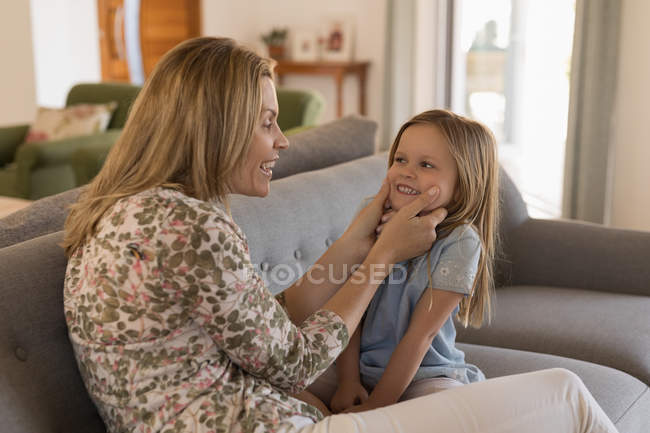 Madre jugando con su hija en la sala de estar en casa - foto de stock