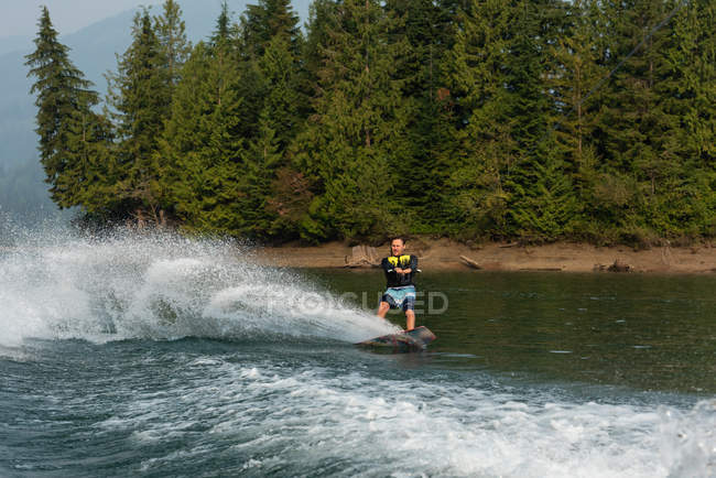 Metà atleta maschio adulto wakeboarding in acqua di fiume — Foto stock
