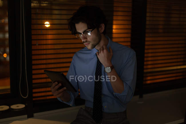 Männliche Führungskraft nutzt nachts digitales Tablet im Büro — Stockfoto