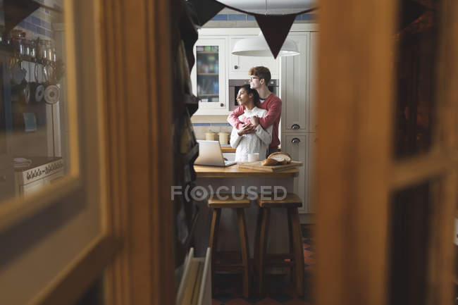 Пара обіймає один одного на кухні вдома — стокове фото