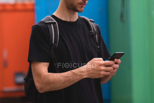 Mid section of young man texting on mobile phone — Stock Photo