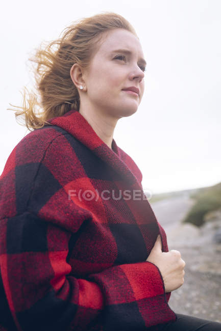 Nachdenkliche rothaarige Frau entspannt sich am Strand. — Stockfoto