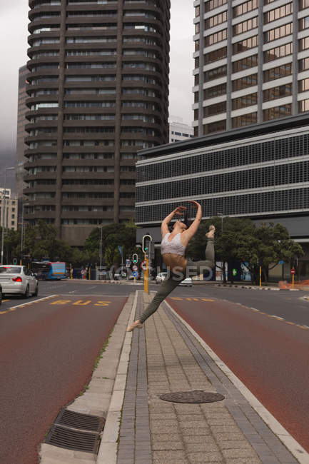 Bailarina urbana elegante practicando danza en la ciudad . - foto de stock