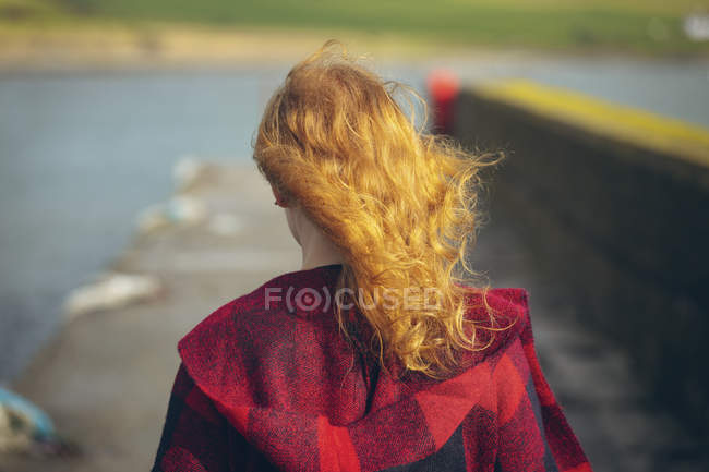 Rear view of redhead woman walking in the beach. — Stock Photo