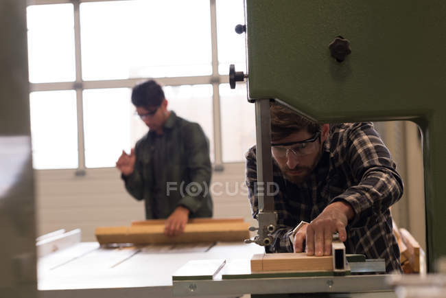Artesanos atentos trabajando en taller industrial - foto de stock