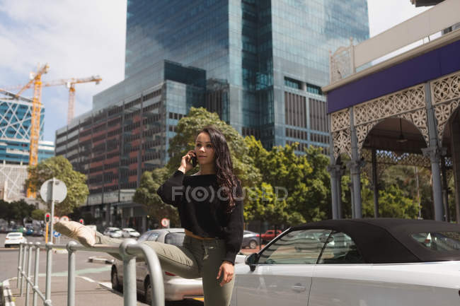 Urban dancer talking on mobile phone while practicing dance in the city. — Stock Photo