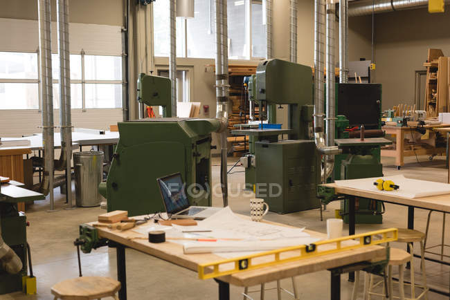 Baupläne mit Laptop und Instrumenten auf Tisch in Werkstatt — Stockfoto